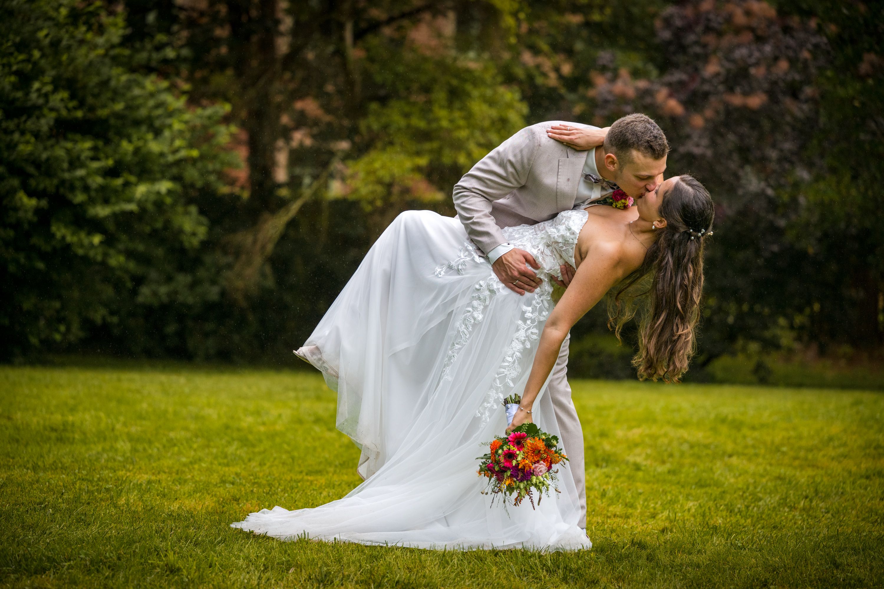 Bräutigam neigt die Braut im Garten der Villa Gückelsberg zum Kuss nach hinten