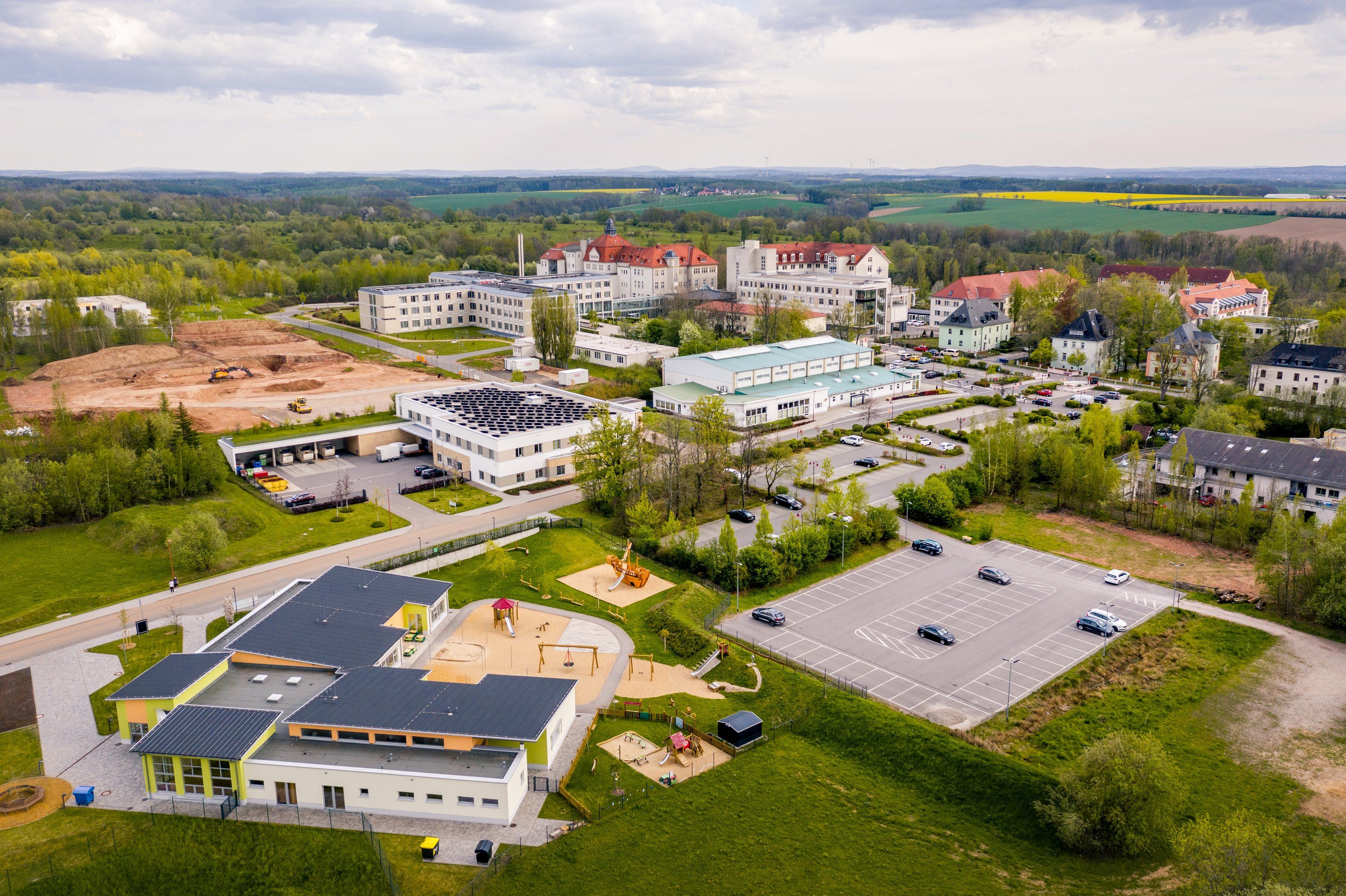 Klinikgelände von oben mit Neubau und Parkanlage