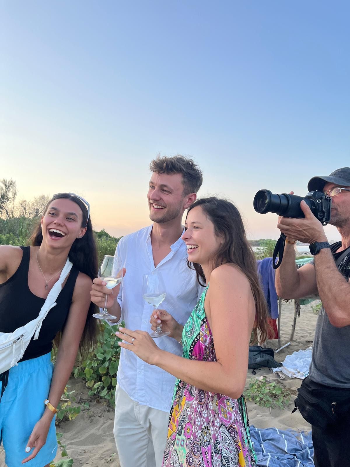 Torree fotografiert ein Paar am Strand, alle lachen laut